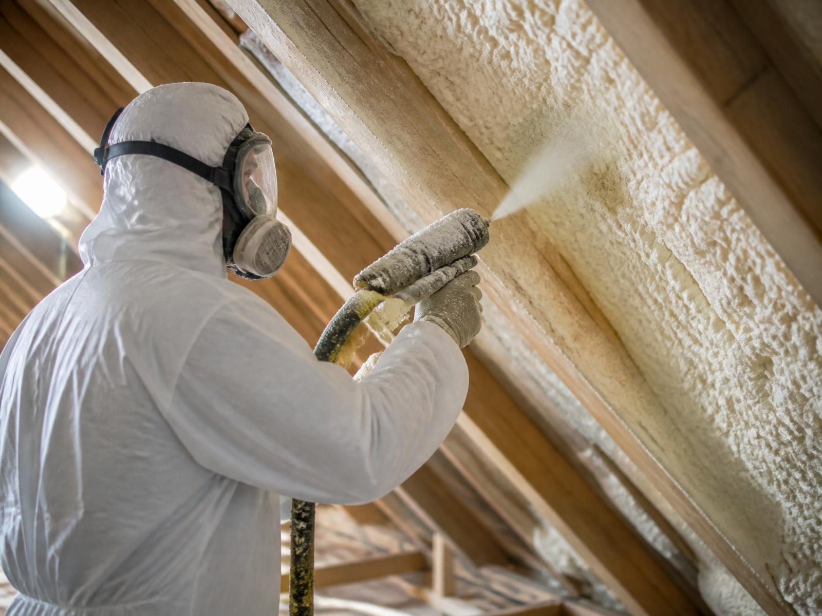 Insulation technician applying closed-cell spray foam in a McAllen attic